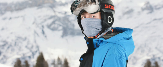 Winter scene of skiing and snowboarding with MCTi Winter Neck Gaiter with Elastic Closure, functioning as a face mask for warmth and comfort in cold and frozen conditions.